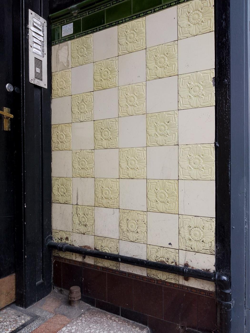 Glazed ornamental wall tiles at the entrance to a tenement close